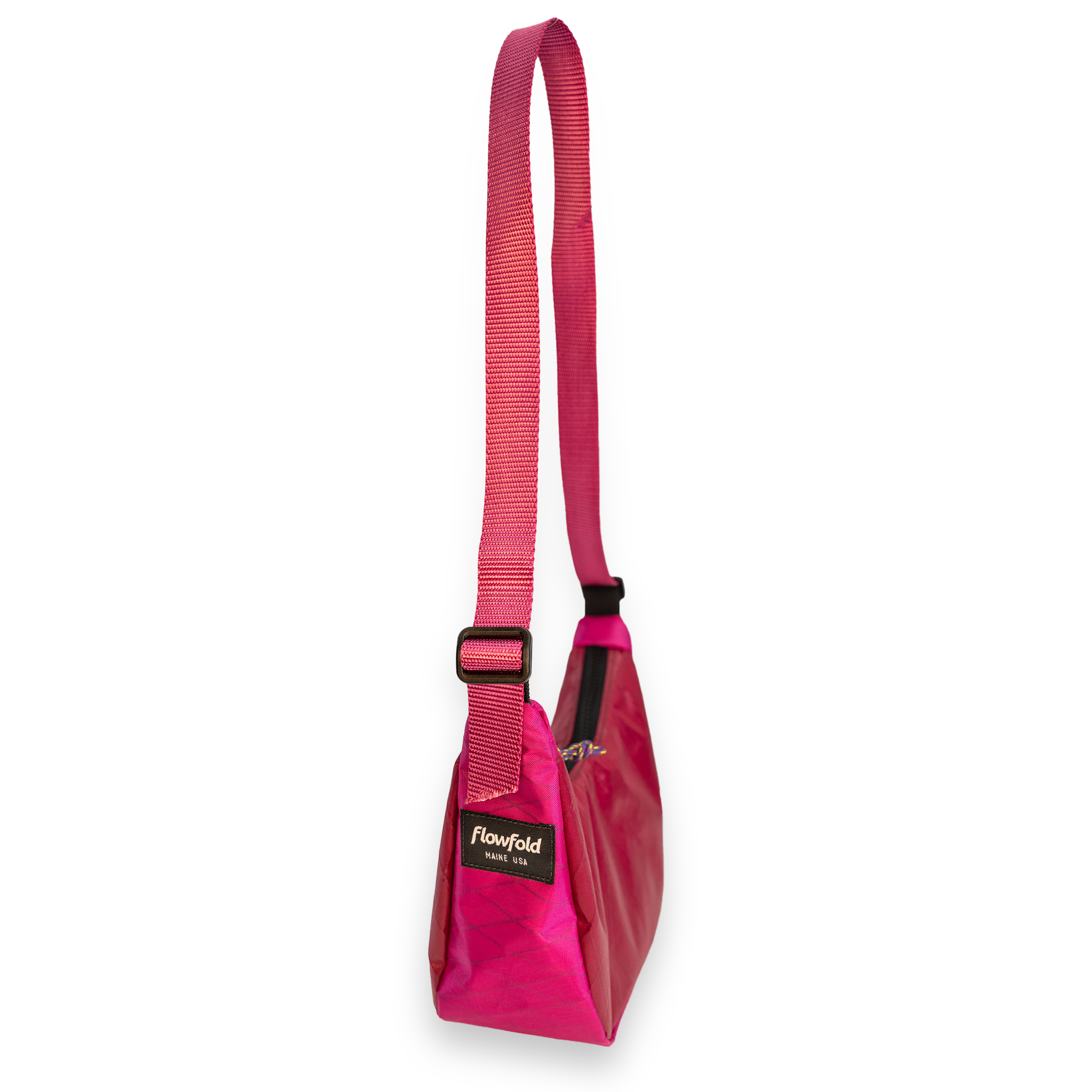A pink shoulder bag with a matching pink webbing strap and a black brand label that reads 'flowfold'.